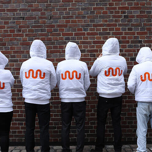 Group of promoters with their backs to the camera and kununu logo on their jackets